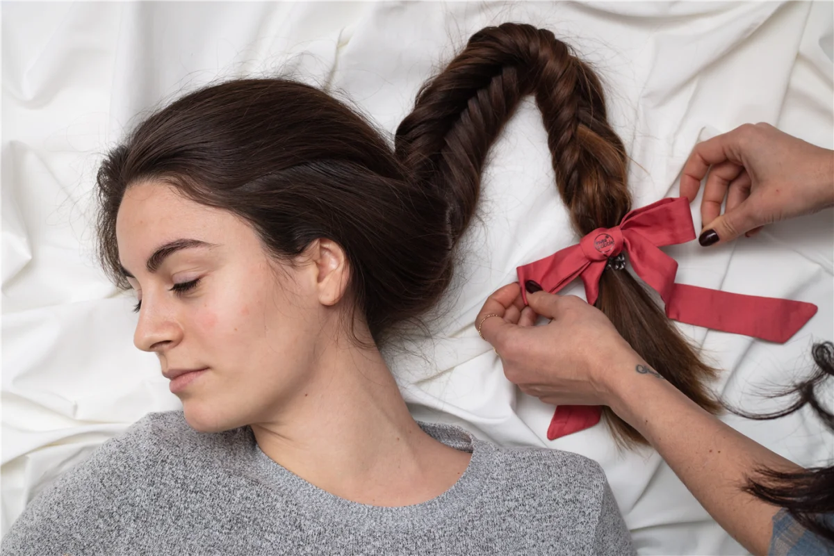 Ragazza sdraiata con treccia morbida, ideale per proteggere la piega di notte